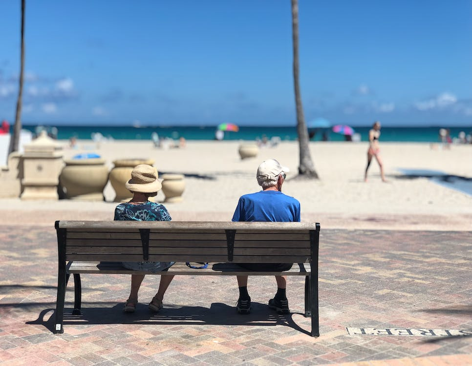A senior couple sitting by the beach.