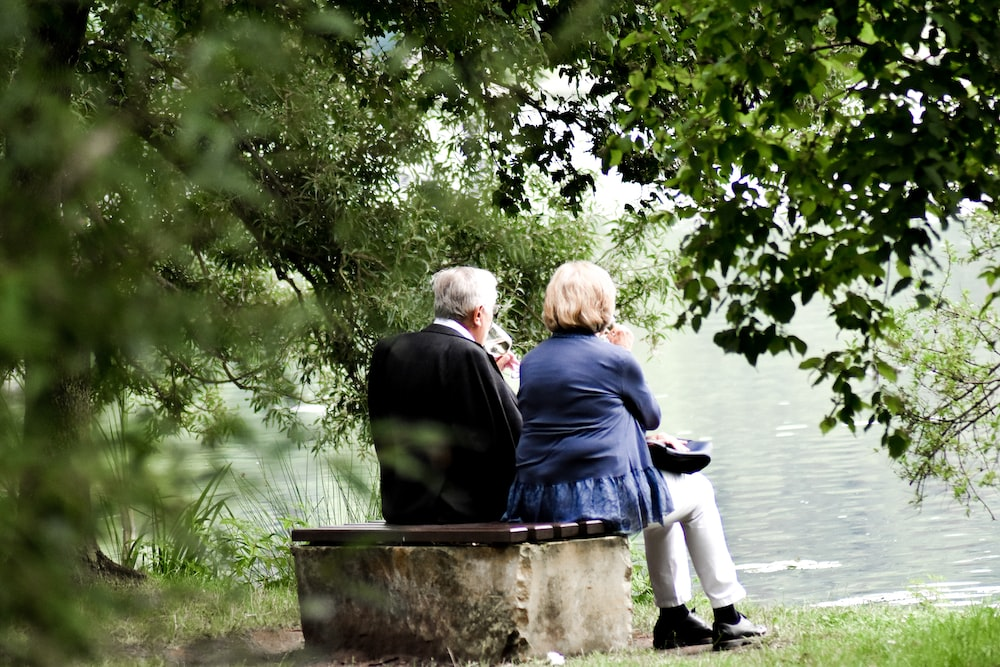  an elderly couple sitting by a lake