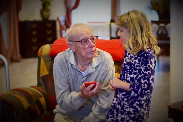 a girl and an elderly man holding a smartphone 