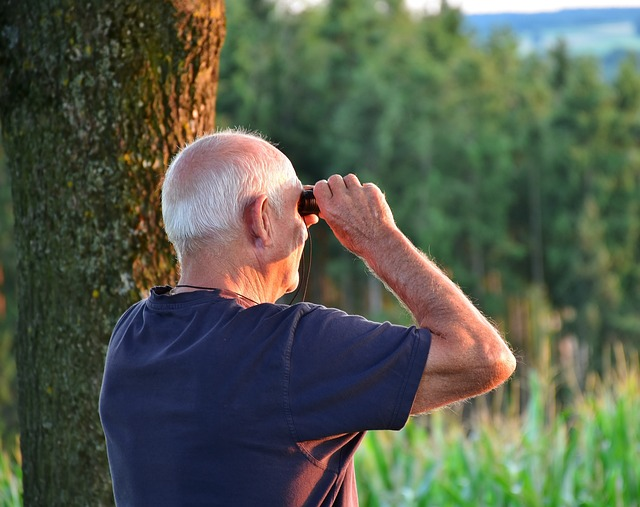 A senior looking through a pair of binoculars