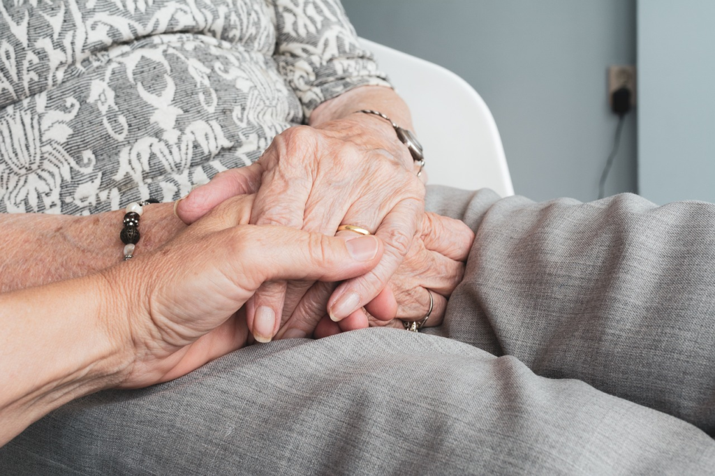 A person holding a senior’s hands