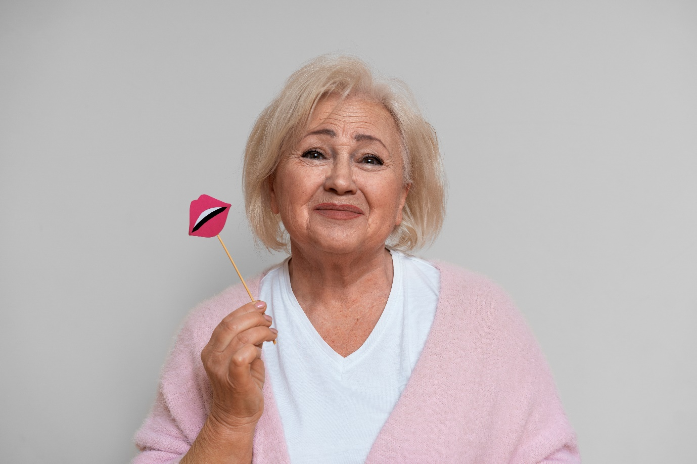 a senior woman holding a stick with a lip sticker