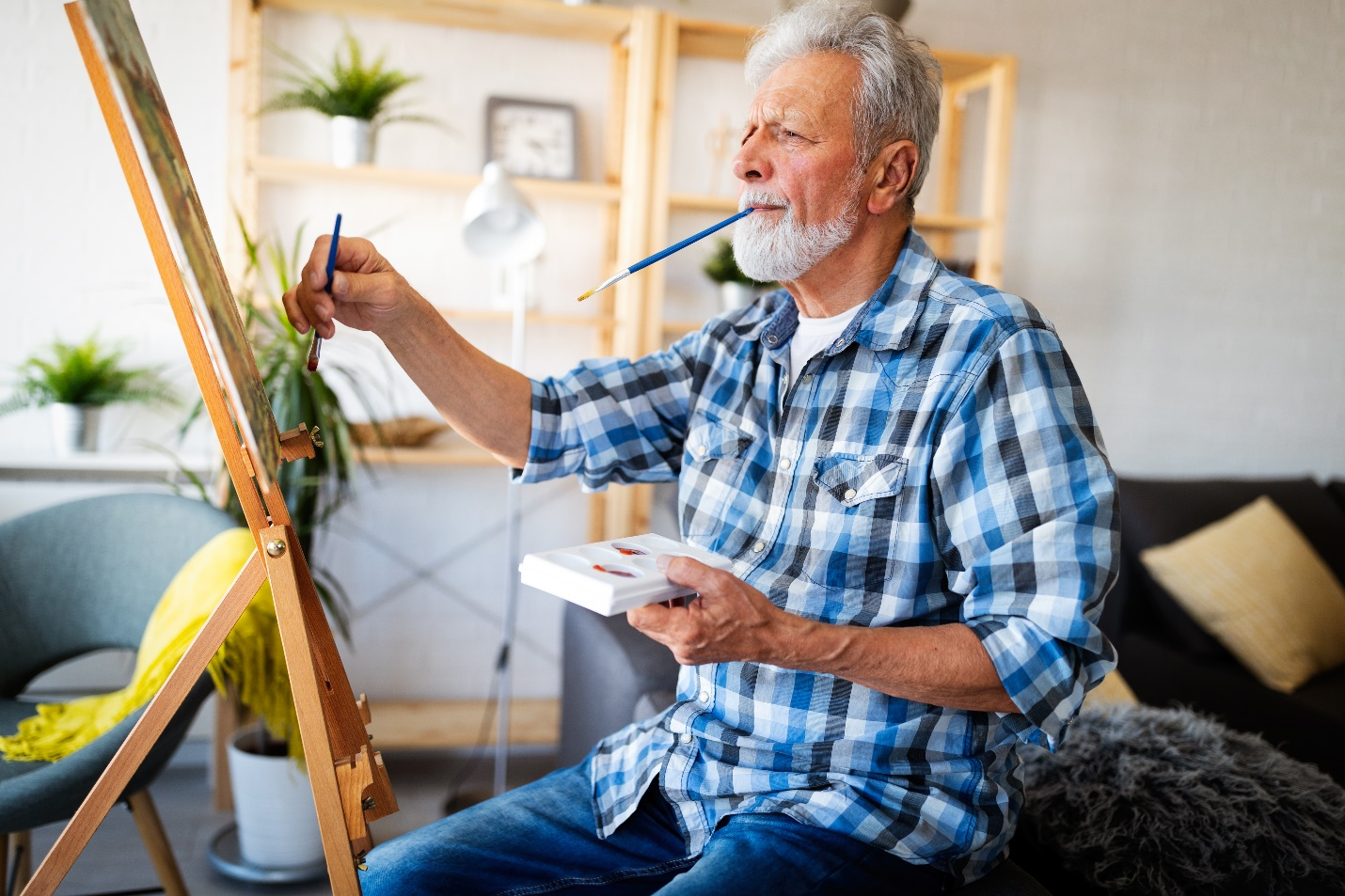 A healthy old man painting on a canvas